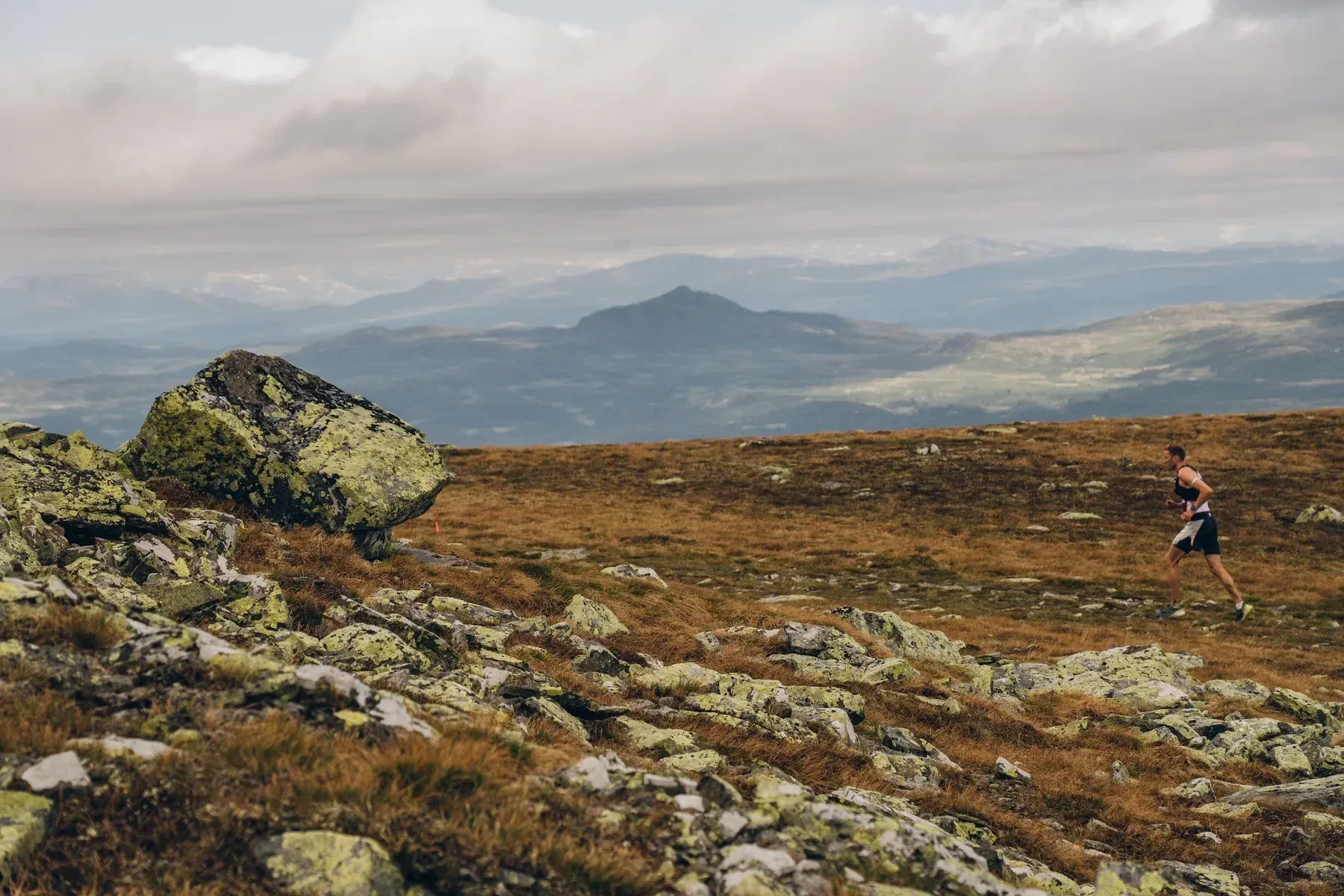 Løper på steinete fjellsti med utsikt over Synnfjellet.